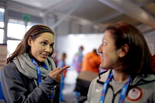 United States bobsled brakeman Lolo Jones, left, gestures to teammate, pilot Elana Meyers, during a television interview as the pair arrive at the 2014 Winter Olympics, Thursday, Jan. 30, 2014, in Sochi, Russia. (AP Photo/David Goldman, Pool)