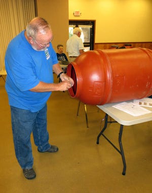 John Bagget works on his rain barrel.