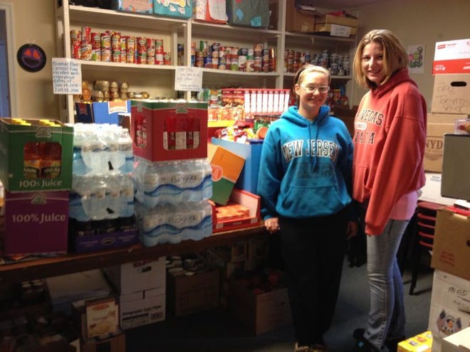 Mercedes Predergast (left) and Melissa Mecca, both bartenders at Gimaro Seafood and Steaks, recently helped deliver 825 pounds of food to the Doylestown Food Pantry. The Montgomery Township restaurant solicited donations from customers, who purchased paper stockings for $2 in return for $5 food vouchers. Staff members donated another $200 in tips to the drive.