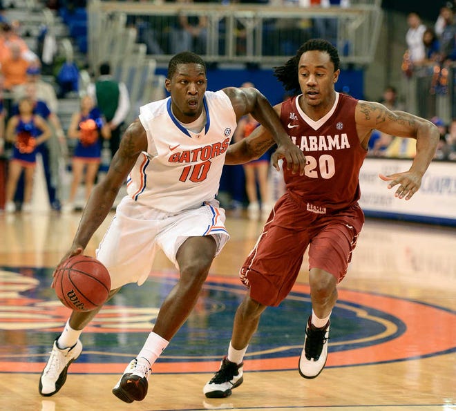 Florida forward Dorian Finney-Smith (10) drives towards the lane as Alabama guard Levi Randolph (20) chases during the second half of an NCAA college basketball game Saturday, Feb. 8, 2014 in Gainesville, Fla. Florida won the game 78-69. (AP Photo/Phil Sandlin)