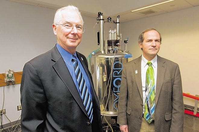 SUNY New Paltz President Donald Christian, left, and Dan Freedman, dean of the School of Science and Engineering, stand with a nuclear magnetic resonance spectrometer.