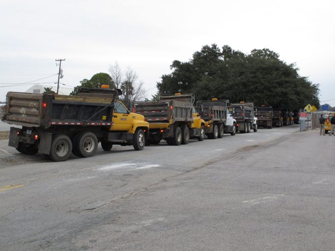 A long line of South Carolina Department of Transportation dump trucks wait to be filled with sand on Monday in Columbia. The DOT and others are preparing for the state's second winter storm in as many weeks. Forecasters say this storm system could include an ice storm.