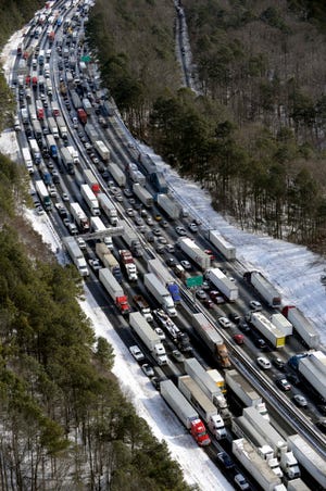 THE ASSOCIATED PRESS / In this Wednesday, Jan. 29, 2014, file aerial photo, traffic is snarled along the Interstate 285 perimeter, north of the metro area after a winter snowstorm, in Atlanta. With memories of thousands of vehicles gridlocked for hours on icy metro Atlanta highways fresh in their minds, emergency officials and elected leaders in north Georgia were preparing Monday, Feb. 10, 2014, for another round of winter weather. (AP Photo/David Tulis, File) 
 THE ASSOCIATED PRESS / Jennifer Poulos reaches in the dairy shelves, Monday, Feb. 10, 2014, in Atlanta.On Monday, officials were quick to act as the winter weather zeroed in. Before a single drop of freezing rain or snow fell, Georgia Gov. Nathan Deal had declared a state of emergency for nearly a third of the state, schools canceled classes and workers were told to stay home. (AP Photo/Atlanta Journal-Constitution, John Spink) 
 THE ASSOCIATED PRESS / In this Thursday, Jan. 30, 2014, file photo, cars abandoned during an earlier snowstorm sit idle along Northside Parkway in Atlanta. With memories of thousands of vehicles gridlocked for hours on icy metro Atlanta highways fresh in their minds, emergency officials and elected leaders in north Georgia were preparing Monday, Feb. 10, 2014, for another round of winter weather. (AP Photo/Atlanta Journal & Constitution, John Spink, File)