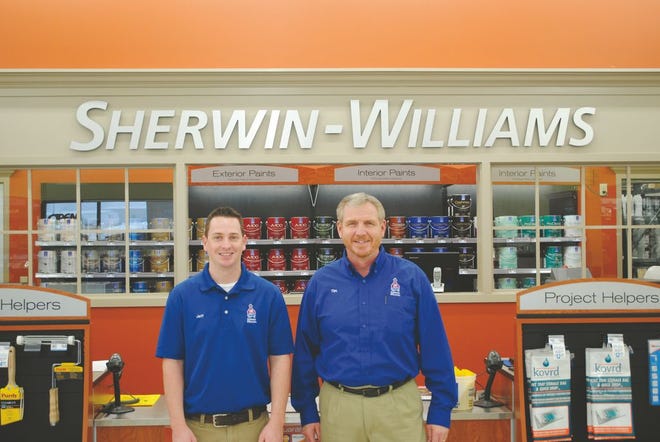 Jeff Aussieker and Tim Raitt pose in front of the Sherwin-Williams sign inside the new store in Morton.