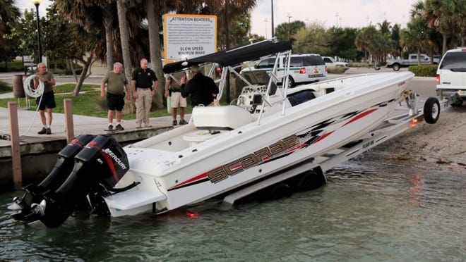 PBSO deputies pull a 30-foot, twin outboard boat from the water at Phil Foster Park on Singer Island. The boat is suspected of bringing a group of illegal immigrants ashore overnight. (Lannis Waters / The Palm Beach Post)