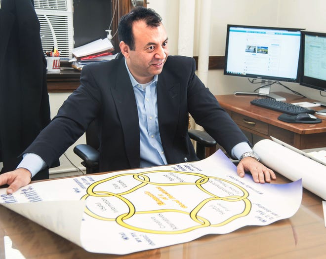 In this Feb. 7, 2014, photo, Ali Abbas, an engineering professor at the University of Illinois, displays a model of the six elements of decision quality that his website Ahoona.com uses to make decisions at his office in Urbana, Ill.