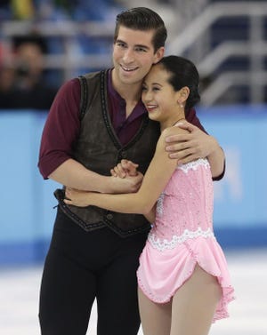 Felicia Zhang and Nathan Bartholomay of the United States embrace after competing in the pairs short program figure skating competition at the Iceberg Skating Palace during the 2014 Winter Olympics, Tuesday, Feb. 11, 2014, in Sochi, Russia. (AP Photo/Darron Cummings)