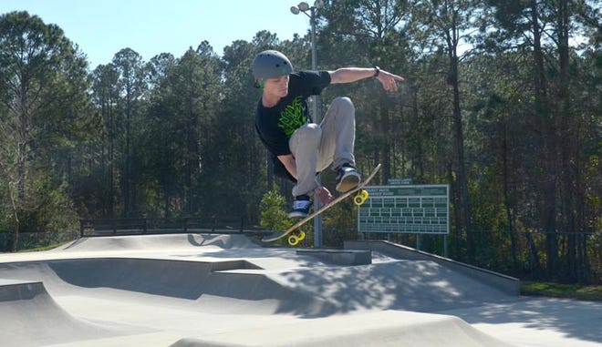 John Rogers does a jump on his skateboard.