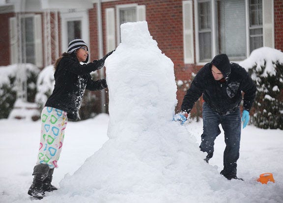 This week's snow has been great for building snowmen. Diana Perez helps her uncle, Cesar Perez, build theirs Wednesday morning.