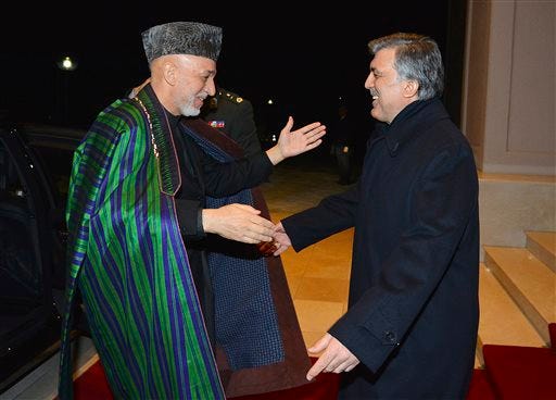 In this photo taken late Wednesday, Feb. 12, 2014 and released by the Turkish Presidency Press Office, Turkish President Abdullah Gul, right, greets his Afghan counterpart President Hamid Karzai in Ankara, Turkey. The White House is dropping its insistence that Afghanistan sign a crucial security pact within weeks, suggesting it could be willing to wait and see whether Karzai's successor might be easier to work with in deciding how many U.S. and international troops remain in Afghanistan when combat concludes at the end of the year. (AP Photo/Turkish Presidency Press Office, Mustafa Oztartan)