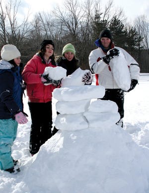 Young people create a snowman during a previous winter carnival.