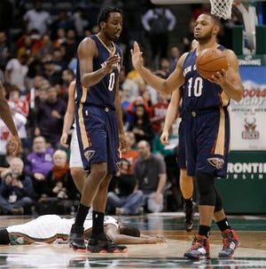 New Orleans Pelicans' Al-Farouq Aminu (0) and Eric Gordon (10) celebrate Aminu's steal from Milwaukee Bucks' Khris Middleton, on ground, in the closing seconds of an NBA basketball game Wednesday, Feb. 12, 2014, in Milwaukee. New Orleans won 102-98. (AP Photo/Jeffrey Phelps)