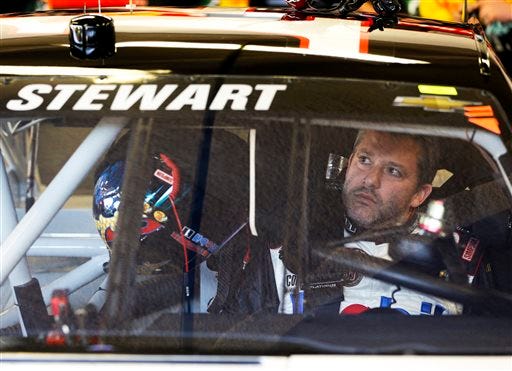 Driver Tony Stewart adjusts the rear view mirror in his car before going out on the track to practice for the NASCAR Sprint Unlimited auto race at Daytona International Speedway in Daytona Beach, Fla., Friday, Feb. 14, 2014. Stewart has not raced in more than six months since he broke two bones in his leg in an August 2013 sprint-car crash.