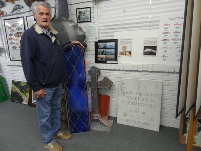 The Destin History and Fishing Museum's Dave Steele shows off some of the latest additions to the museum, a stained glass window, a cross that stood atop of the St. John’s Greek Orthodox Church, as well as a roof tile and a plaque dedicated in memory of John Maltezo, a founding father of the iconic chapel that once stood along U.S. 98 in the heart of Destin.