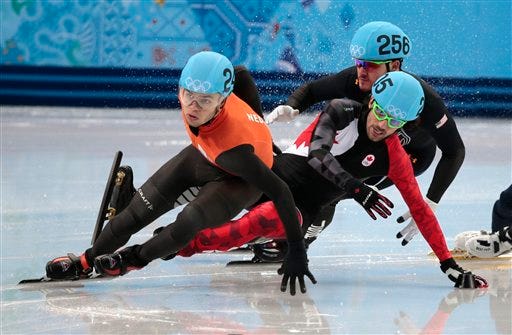 Charles Hamelin of Canada, centre, crashes out with Eduardo Alvarez of the United States, right, as they compete with Sjinkie Knegt of Netherlands in a men's 1000m short track speedskating quarterfinal at the Iceberg Skating Palace during the 2014 Winter Olympics, Saturday, Feb. 15, 2014, in Sochi, Russia.