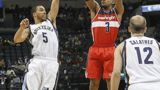 Washington Wizards guard Bradley Beal (3) shoots against Memphis forward Nick King (5) and guard Nick Calathes (12) in the first half of an NBA basketball game, Tuesday, Feb. 11, 2014, in Memphis, Tenn. (AP Photo/Lance Murphey)