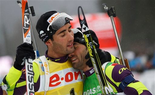 FILE - In this March 11, 2012 file photo, Martin Fourcade of France, left, hugs his brother Simon Fourcade after winning the men's mass start 15K race at the Biathlon World Championships in Ruhpolding, Germany. When Martin Fourcade won his first Olympic gold on Feb. 13, 2014, one of the best feelings for the French biathlete was celebrating in the finish area with the teammate he grew up trying to beat _ older brother Simon. All over Sochi, siblings are competing next to each other _ some as teammates, some as rivals for the gold medal.