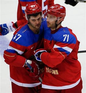 Russia forward Ilya Kovalchuk, right, is congratulated by Russia forward Alexander Radulov after hitting the winning shot in a shootout against Slovakia during a men's ice hockey game at the 2014 Winter Olympics, Sunday, Feb. 16, 2014, in Sochi, Russia. Russia won 1-0. (AP Photo/Julio Cortez)