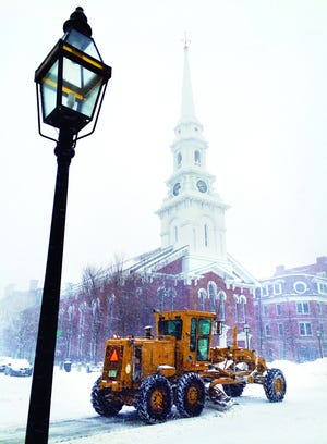 Heavy snow removal equipment from Portsmouth Public Works makes continuous loops around Market Square on Thursday..