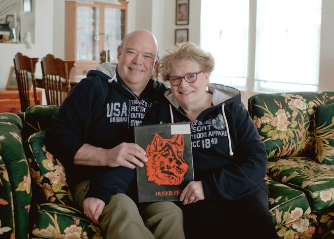 Clyde and Dana Grooms in their home with their high school yearbook. The couple met just before Clyde's 16th birthday and have been together for 40 years.