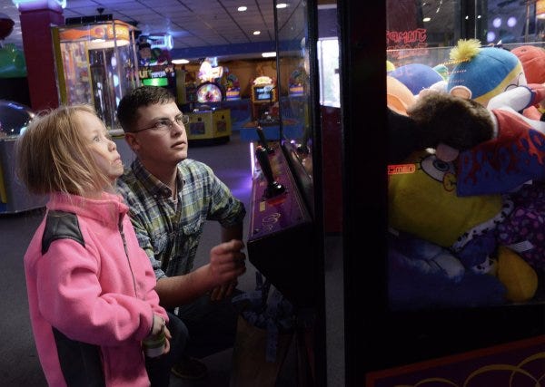 Kyle Carlton tries to maneuver a claw to grab a small stuffed animal as his daughter, Khloe Plaisted, 4, watches inside Fun Fun Fun on Cumberland Road on Friday.