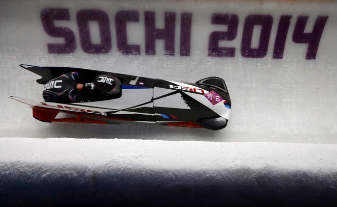 The team from the United States USA-1, piloted by Steven Holcomb and brakeman Steven Langton, take a curve during the men's two-man bobsled competition at the 2014 Winter Olympics.