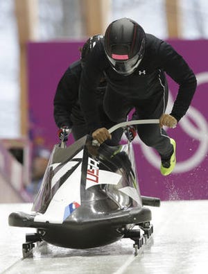 The team from the United States USA-1, piloted by Elana Meyers, start a run during a women's bobsleigh training session at the 2014 Winter Olympics Saturday in Krasnaya Polyana, Russia. (AP Photo/Dita Alangkara)