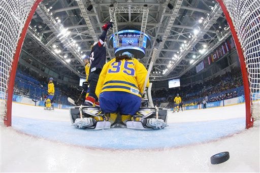 Lyndsey Fry of the United States celebrates Megan Bozek's goal as Goalkeeper Valentina Wallner of Sweden sits on her knees during the second period of the 2014 Winter Olympics women's semifinal ice hockey game at Shayba Arena, Monday, Feb. 17, 2014, in Sochi, Russia.