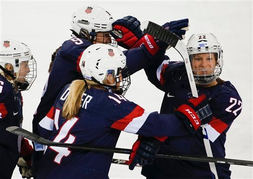Kacey Bellamy of the United States, right, is congratulated by teammates after scoring a goal against Sweden during the first period of the 2014 Winter Olympics women's semifinal ice hockey game at Shayba Arena Monday, Feb. 17, 2014, in Sochi, Russia. Bellamy played college hockey for the University of New Hampshire.
