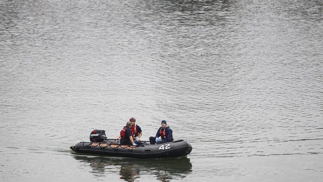 Austin police and rescue officials investigating at the scene of a body found in Lady Bird Lake on Monday.