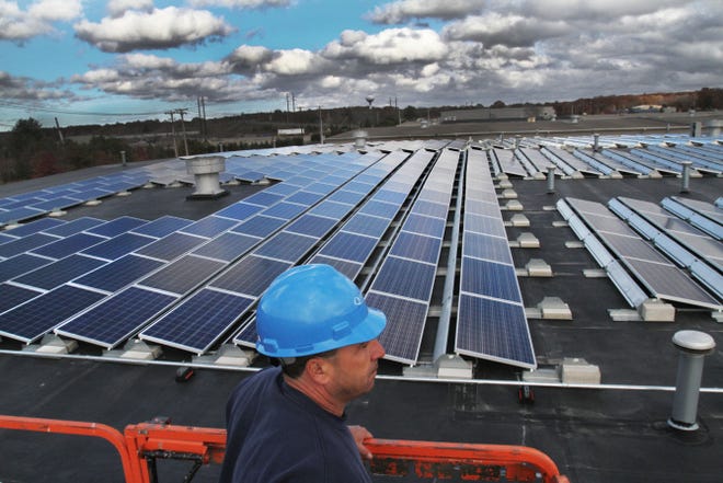 Quonset Business Park has the second-largest solar array in the state, a 2.4-megawatt system that Boston developer Nexamp built last summer on top of two industrial buildings. Here, Anthony Craveiro of the Quonset Development Corporation shows the panels to visitors in November.