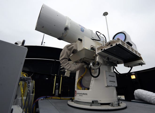 In this July 30, 2012, photo provided by the U.S. Navy, a laser weapon sits temporarily installed aboard the guided-missile destroyer USS Dewey in San Diego. The Navy plans to deploy its first laser on a ship in 2014 and intends to test an electromagnetic rail gun prototype aboard a vessel within the following two years.