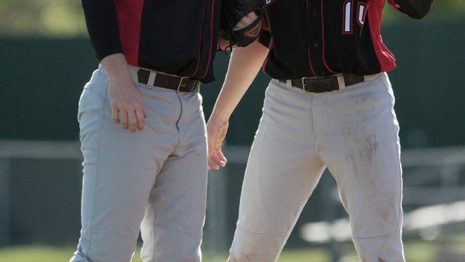First baseman Tyler Payne (14) offers pitcher Connor Mayes support during the Cavaliers 2013 season.