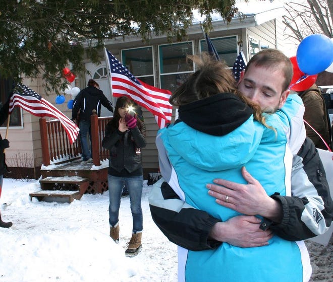 Rich Conklin hugs his mother, Marietta, in front of the family's Dundee home. When Conklin, a staff sergeant in the U.S. Army arrived in his hometown Saturday, he was greeted by a small army of grateful and thankful neighbors and friends.