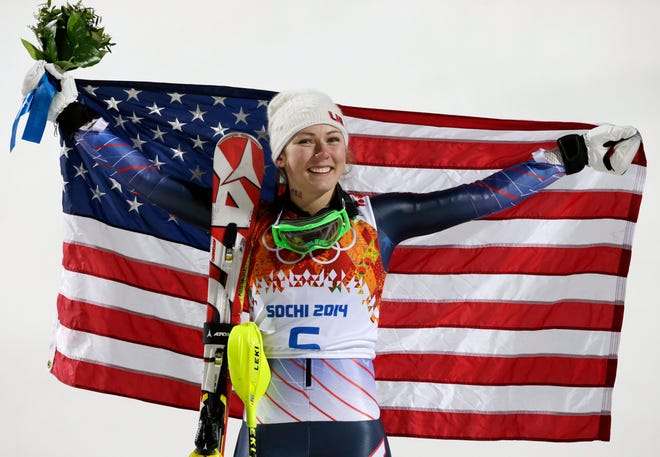 Mikaela Shiffrin of the United States poses for photographers with the U.S. flag in Krasnaya Polyana, Russia, after winning the gold medal in women's slalom.