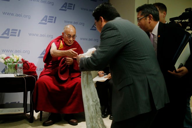 The Dalai Lama prepares to bless an audience member during a break between 
panel discussions at an event called 
"Happiness, Free Enterprise, and Human Flourishing" Thursday at the American 
Enterprise Institute in Washington.AP PHOTO / CHARLES DHARAPAK
