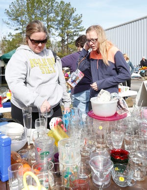 Jennifer and Taylor Hillbrand consider glassware at the Knights of Columbus yardsale. The two-day event wrapped up Saturday.