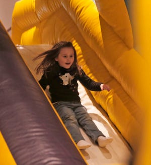 Sydney White, 5, takes a ride down an inflatable slide during Saturday’s Fun Day at New Bern Riverfront Connvention Center.