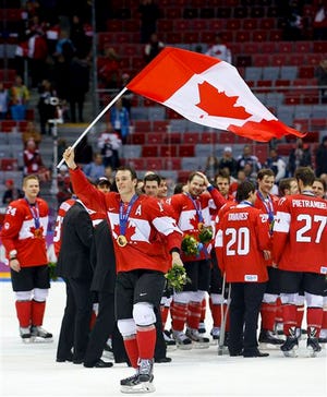 Canada forward Jonathan Toews waves the Canadian flag after Canada beat Sweden 3-0 in the men's gold medal ice hockey game at the Winter Olympics, Sunday.