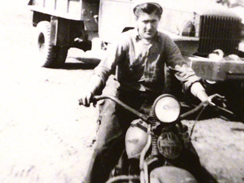 JD Radford poses on a motorcycle during World War II. He said some officers had stolen it.