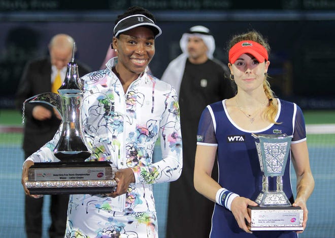 CAPTION CORRECTION, CORRECTS THE DATE - Venus Williams of the U.S., right, holds the trophy next to runner up Alize Cornet of France during the final match of Dubai Duty Free Tennis Championships in Dubai, United Arab Emirates, Saturday, Feb. 22, 2014. (AP Photo/Kamran Jebreili)