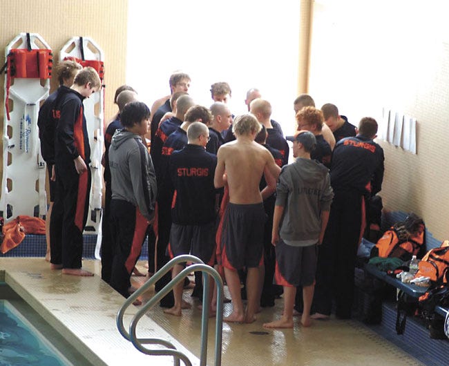 The Sturgis swim team chats with coach Andy Feyes at the SMAC East league meet.