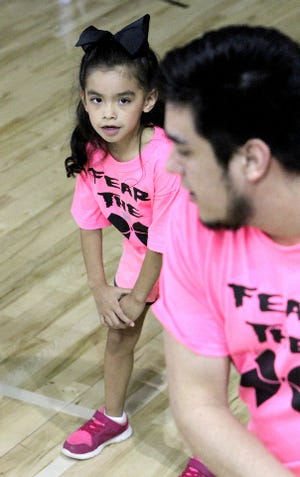 Jamie Mitchell Times Record - Marley Jimenez practices her cheer routine with UAFS cheerleader Joe Amezcua, Saturday, Feb 22, 2014, before the annual UAFS "Pink Zone," basketball games at the Stubblefield Center. As part of the breast cancer awareness event, the UAFS cheerleaders hosted the "Fear the Bow," cheer clinic Saturday for more than 150 area participants, culmanating in half-time performances at the UAFS basketball game agaisnt Oklahoma Panhandle State University. Marley is the 6-year-old daughter of Dora and Javier Jimenez of Howe, Ok.