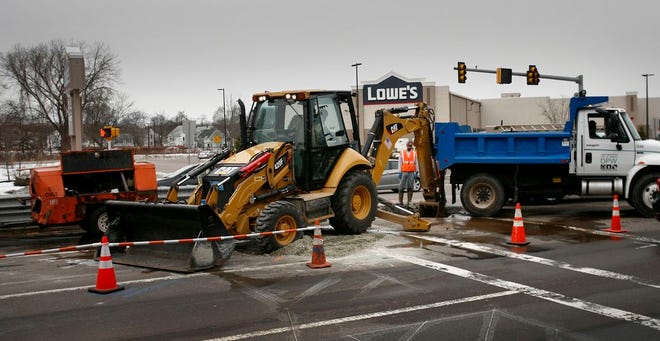 Public works department workers in Quincy workers repair a water main break on Burgin Parkway at Penn Street in West Quincy on Sunday, Feb. 23, 2014. The break necessitated a lane closure for much of the day.