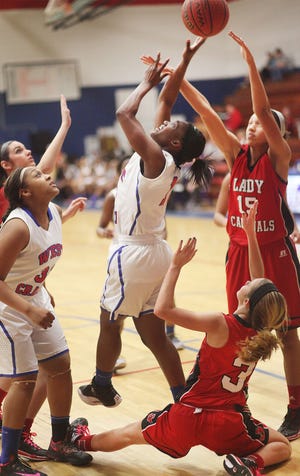 West Craven guard Jamie Cherry goes up for two of her 43 points among a flock of Jacksonville 
Cardinals Monday as teammate Ronkeia Lewis looks on.