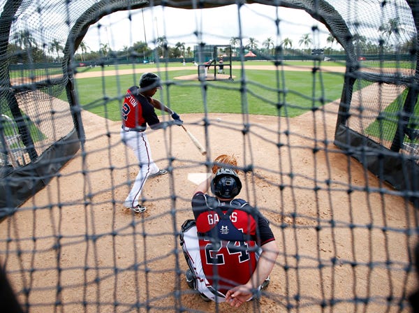 Atlanta Braves center fielder B.J. Upton swings at a pitch with Evan Gattis catching during a spring training workout Monday in Kissimmee, Fla. (Alex Brandon | Associated Press)
