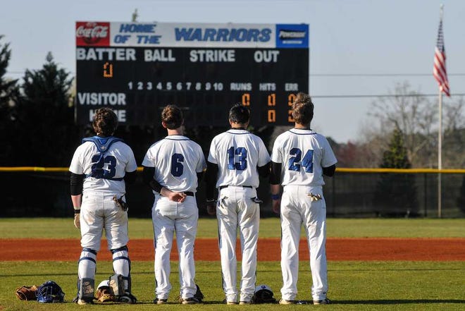Oconee County players listen as the national anthem plays during a high school baseball game in Watkinsville, Ga., Wednesday, March 27, 2013. (AJ Reynolds/Staff)