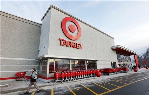 FILE - In this Dec. 19, 2013, file photo, a passer-by walks near an entrance to a Target retail store in Watertown, Mass. Target Corp. reports quarterly financial results before the market opens on Wednesday, Feb. 26, 2014. (AP Photo/Steven Senne, File)