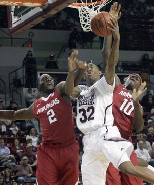 Mississippi State's Craig Sword (32) drives between Arkansas defenders Alandise Harris (2) and Bobby Portis (10) during the first half of an NCAA college basketball game in Starkville, Miss., Saturday, Feb. 22, 2014. (AP Photo/Jim Lytle)