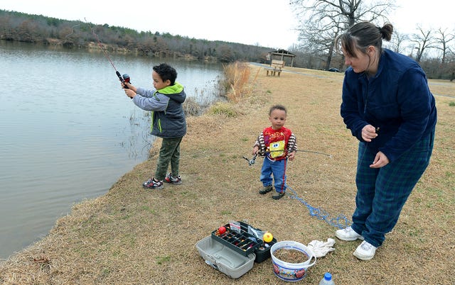 BRIAN D. SANDERFORD TIMES RECORD Patrick Collier, 4, from left, of Fort Smith keeps an eye on his line, while his brother, Javarious Collier, 2, grabs a fishing pole as their mother Bobbie Collier, baits the hook on Tuesday, Feb. 25, 2014 at Wells Lake. The boys were looking for their first fish at the lake at Janet Huckabee Arkansas River Valley Nature Center.
